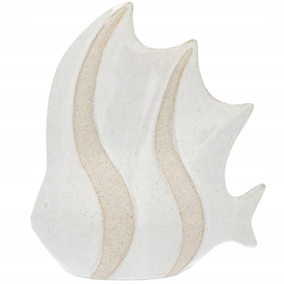 Ceramiczna figurka w kształcie ryby. Posiada gładką, białą (śmietankową) powierzchnię, urozmaiconą dwoma pionowymi pasami o wyraźnej, szorstkiej fakturze przypominającej ziarenka piasku. Zdjęcie produktowe typu packshot wykonane na jednolitym, białym tle, doskonale prezentujące kształt i zróżnicowaną powierzchnię ozdoby
