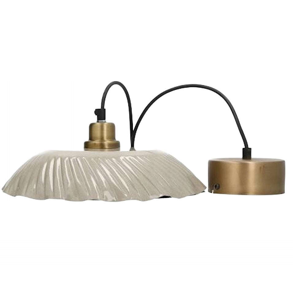 Zdjęcie produktowe na czystym, białym tle (packshot). Lampa wisząca składająca się z szerokiego, plisowanego (falistego) klosza w jasnym, szarobeżowym kolorze o wysokim połysku. Klosz połączony jest ze szczotkowaną, mosiężną oprawką, od której odchodzi czarny przewód zasilający. Obok widoczna jest również okrągła, mosiężna podsufitka.