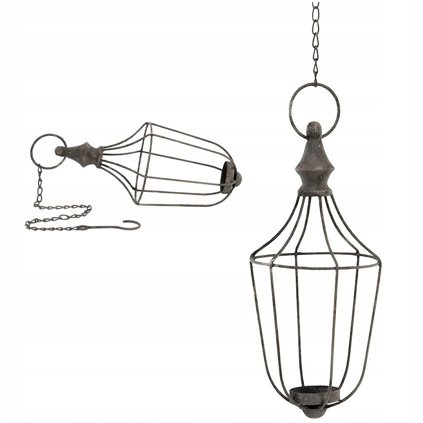 Metalowy lampion dekoracyjny o ażurowej konstrukcji przypominającej klatkę, wyposażony w łańcuch z haczykiem. Powierzchnia metalu ma surowe, celowo postarzane wykończenie z rdzawym nalotem (efekt patyny). Zdjęcie produktowe na jednolitym, białym tle prezentuje lampion w dwóch pozycjach: wiszącej oraz leżącej.