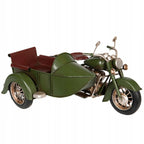 Zdjęcie produktowe na gładkim, białym tle (packshot). Metalowy model motocykla w kolorze oliwkowej zieleni z dołączonym wózkiem bocznym. Figurka posiada brązowe detale imitujące skórzane siedzenia oraz srebrne, lekko przecierane elementy silnika, ramy i reflektorów, co nadaje jej surowy, industrialny wygląd w stylu vintage.