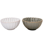 Zdjęcie produktowe na białym tle (packshot). Zestaw dwóch głębokich, ceramicznych miseczek z ryflowanymi (żłobionymi) ściankami. Miska po lewej jest w kolorze złamanej bieli, a po prawej w zgaszonym, szarozielonym odcieniu. Obie posiadają subtelnie przecierane krawędzie, nadające im rustykalny charakter.