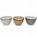 Zestaw trzech małych miseczek ceramicznych o organicznym, lekko nieregularnym kształcie, przypominającym rękodzieło. Naczynia pokryte są błyszczącym szkliwem w trzech stonowanych barwach: kremowej, beżowej oraz szaro-zielonej. Brzegi wykończono kontrastującym, ciemnym rantem, który nadaje im charakteru. Zdjęcie produktowe typu packshot wykonane na jednolitym, białym tle, doskonale prezentujące kolory i lśniącą fakturę.