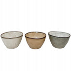 Zestaw trzech małych miseczek ceramicznych o organicznym, lekko nieregularnym kształcie, przypominającym rękodzieło. Naczynia pokryte są błyszczącym szkliwem w trzech stonowanych barwach: kremowej, beżowej oraz szaro-zielonej. Brzegi wykończono kontrastującym, ciemnym rantem, który nadaje im charakteru. Zdjęcie produktowe typu packshot wykonane na jednolitym, białym tle, doskonale prezentujące kolory i lśniącą fakturę.