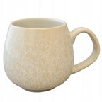 Zdjęcie produktowe na białym tle (packshot). Pękaty kubek ceramiczny z dużym uchem w jasnokremowym odcieniu. Powierzchnię naczynia pokrywa reaktywne szkliwo tworzące subtelną, nieregularną, lekko spękaną fakturę w jaśniejszych tonacjach.