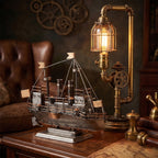 Ręcznie wykonany, metalowy model statku wyeksponowany na drewnianym blacie. Obok statku stoi oryginalna lampa stołowa w stylu steampunk, zbudowana z mosiężnych rurek, kół zębatych i żarówki typu Edison w drucianej osłonie. W ciemnym, nastrojowym tle widać skórzany fotel typu chesterfield oraz dekoracyjne koła zębate na ścianie