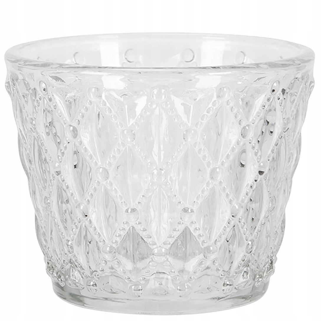 Zdjęcie produktowe na białym tle (packshot). Przezroczysty, szklany świecznik na małe świeczki typu tealight. Naczynie ma kształt lekko rozszerzającego się ku górze kubeczka. Jego ścianki zdobi bogaty, tłoczony wzór w kształcie rombów, uformowany z drobnych, wypukłych kropeczek.